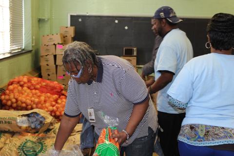 Team member Bridgett Williamson and others pack food bags at FISH (Food in Service to the Homebound)
